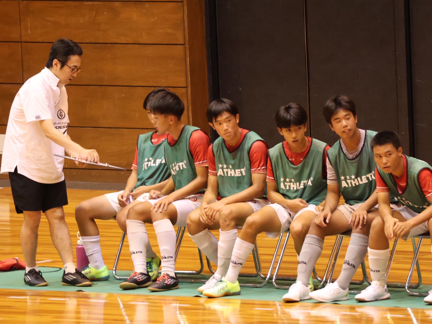 試合の合間、選手一人ひとりに声をかけるU-15コーチ